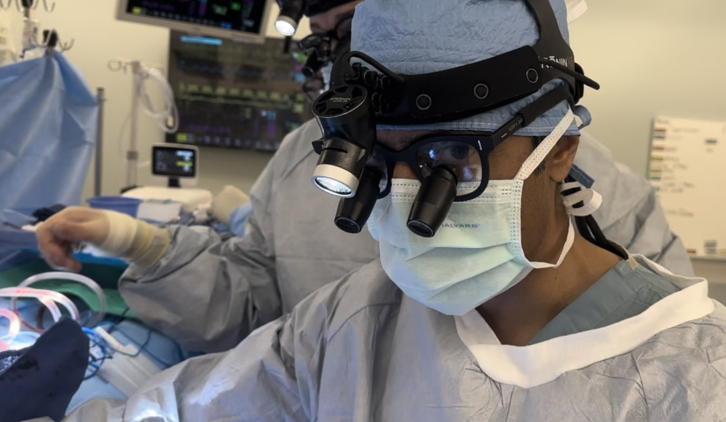 Dr. Bari in the operating room wearing surgical loupes and a headlight